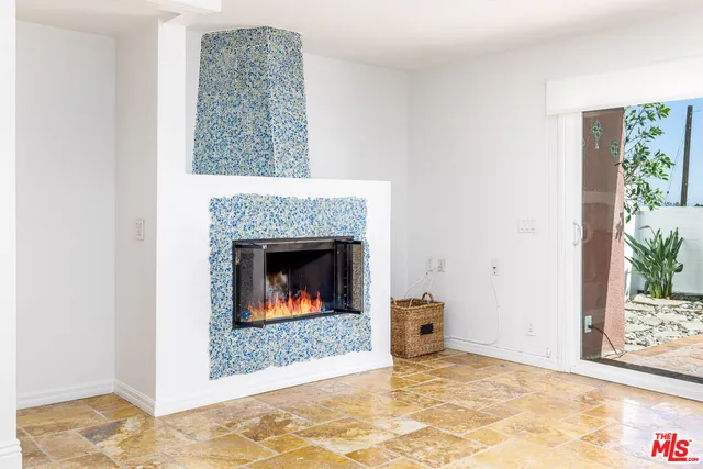 a view of an empty room with a fireplace and a window