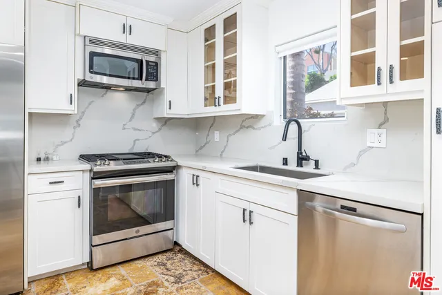 a kitchen with stainless steel appliances a stove microwave and sink