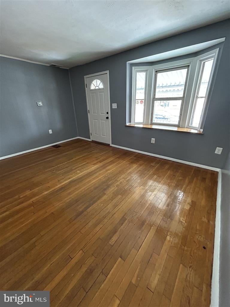 8333 Kavanagh Road Baltimore, MD 21222 - Photo 2 of 30 an empty room with wooden floor and windows