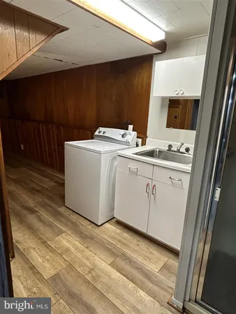 a utility room with a sink a cabinetry and a window