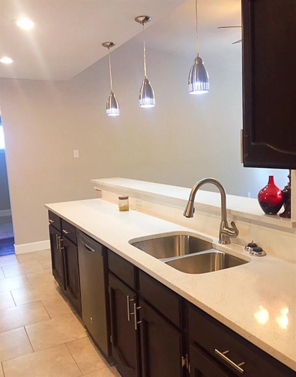 3305 Spaniel Drive Austin, TX 78759 - Photo 19 of 20 A well-appointed kitchen features a double stainless steel sink and modern pendant lighting.