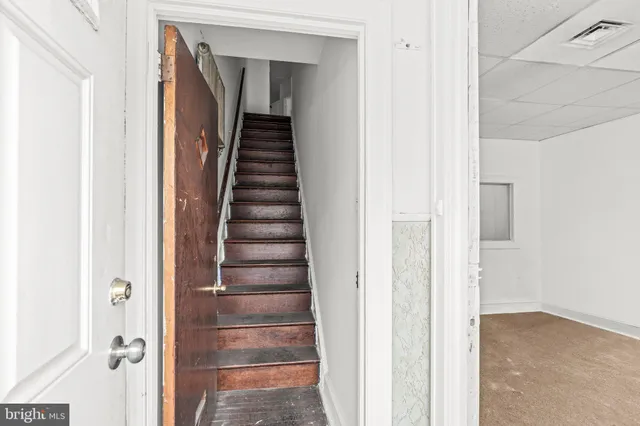 a view of a hallway with front door wooden floor and stairs