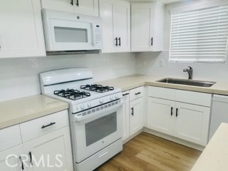 10801 Pine Street Los Alamitos, CA 90720 - Photo 7 of 24 a kitchen with white cabinets and white appliances