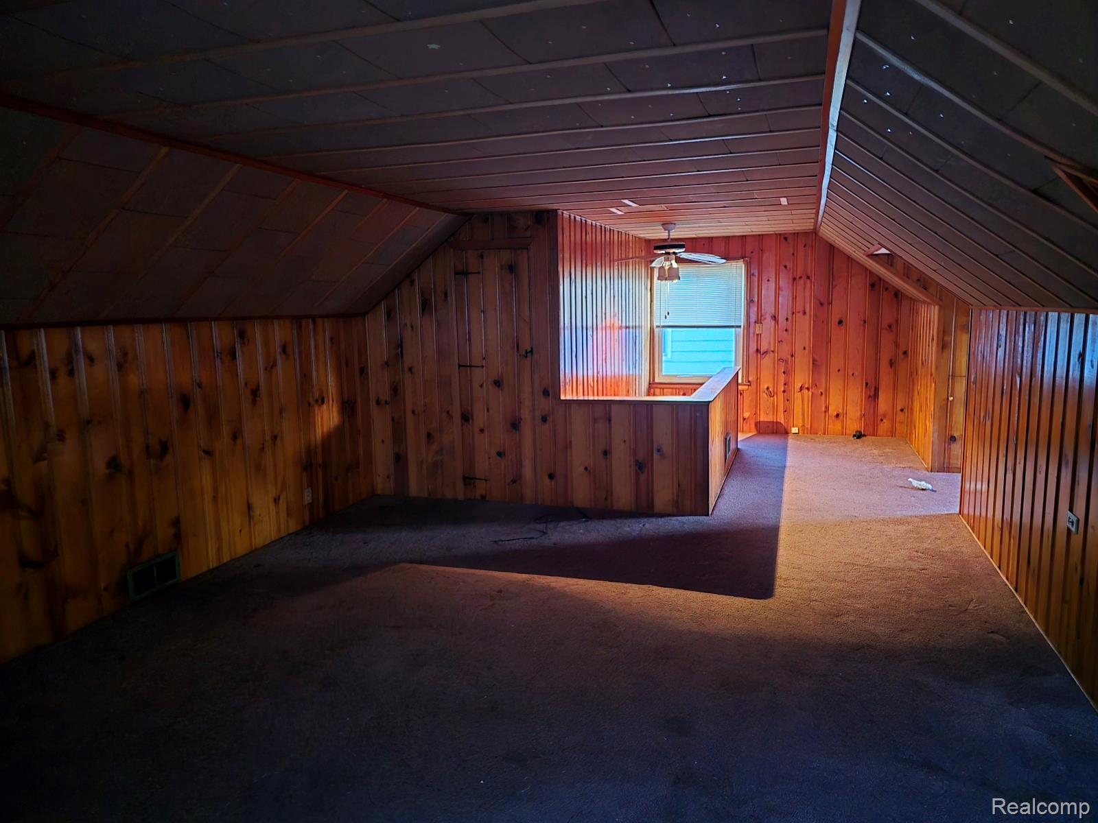 803 Commonwealth Avenue Flint, MI 48503 - Photo 15 of 15 Additional living space featuring lofted ceiling, carpet floors, and wood walls