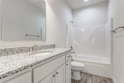 2407 North Hickory Street Sherman, TX 75092 - Photo 5 of 9 a bathroom with a granite countertop sink a toilet and shower