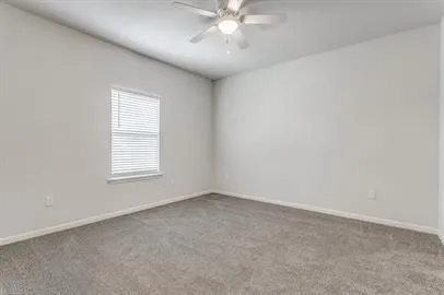 an empty room with a window and a fan