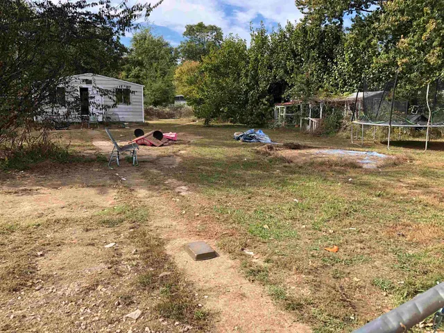 a backyard of a house with fire pit and chairs