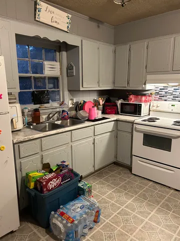 a kitchen with a sink stove and cabinets