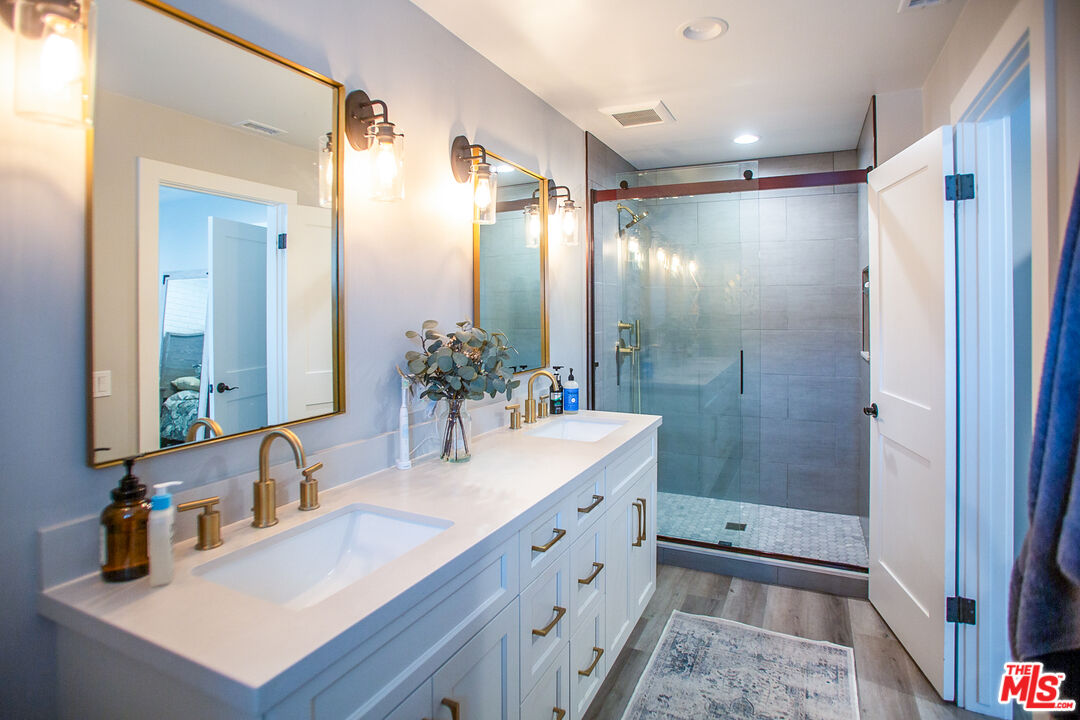 137 Main Street Los Alamos, CA 93440 - Photo 31 of 52 a bathroom with a shower sink vanity and mirror
