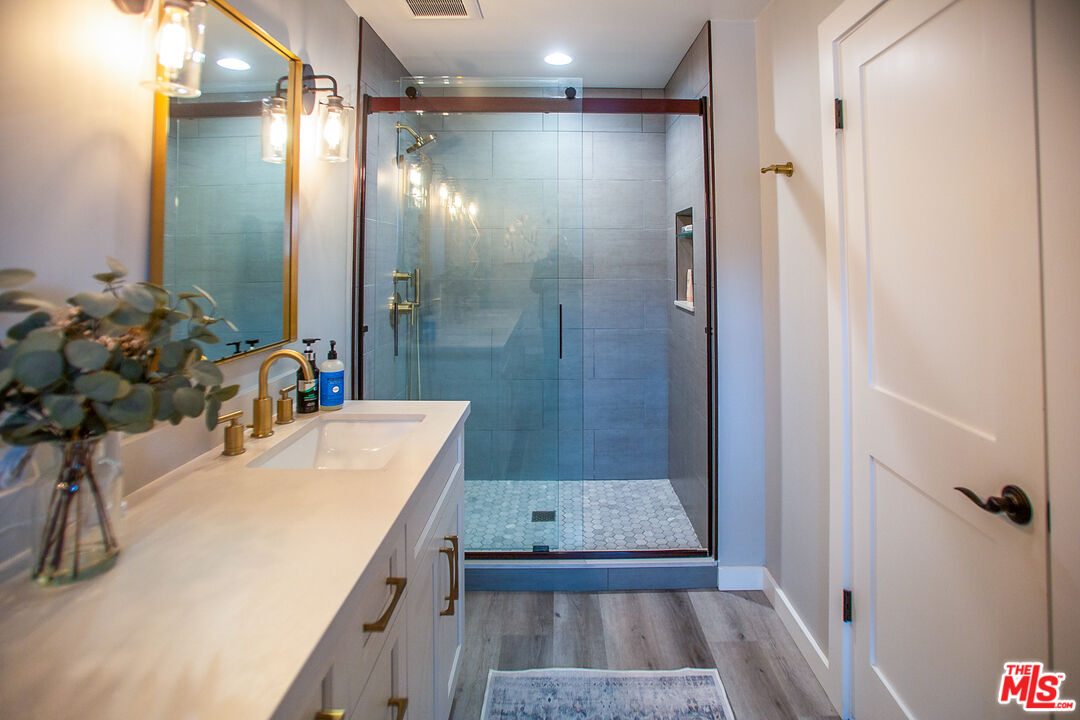 137 Main Street Los Alamos, CA 93440 - Photo 32 of 52 a bathroom with a sink vanity granite tub shower and a mirror