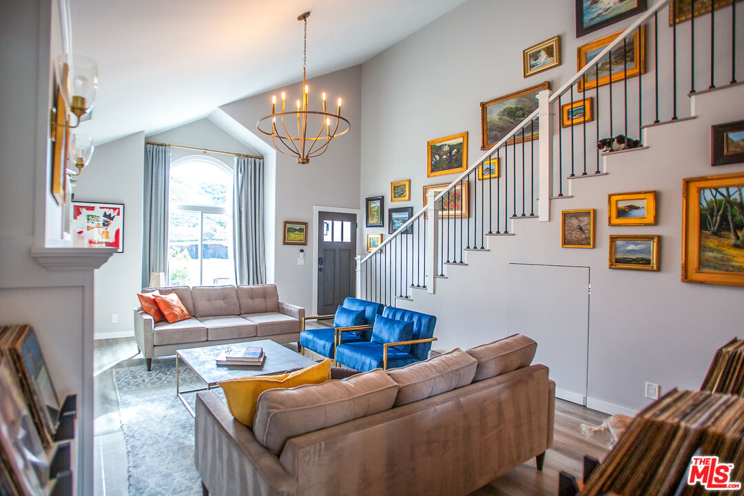 137 Main Street Los Alamos, CA 93440 - Photo 6 of 52 a living room with furniture a rug and a chandelier