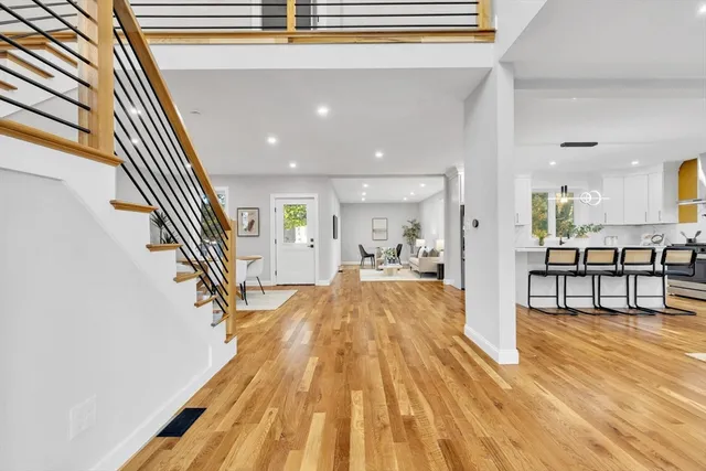 a view of a living room and kitchen with stainless steel appliances wooden floor
