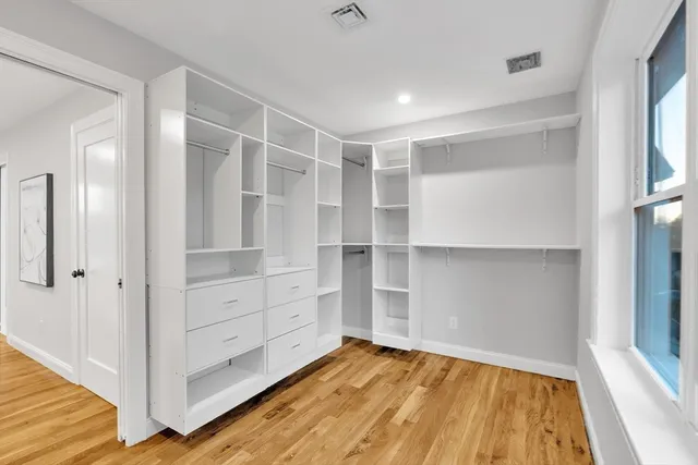 a view of walk in closet with empty racks