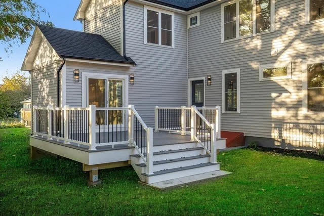 a view of a house with a yard and wooden deck