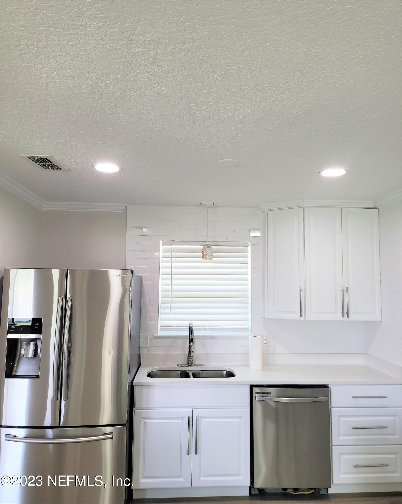 2627 Adele Road Jacksonville, FL 32216 - Photo 12 of 27 a kitchen with stainless steel appliances a refrigerator sink and microwave