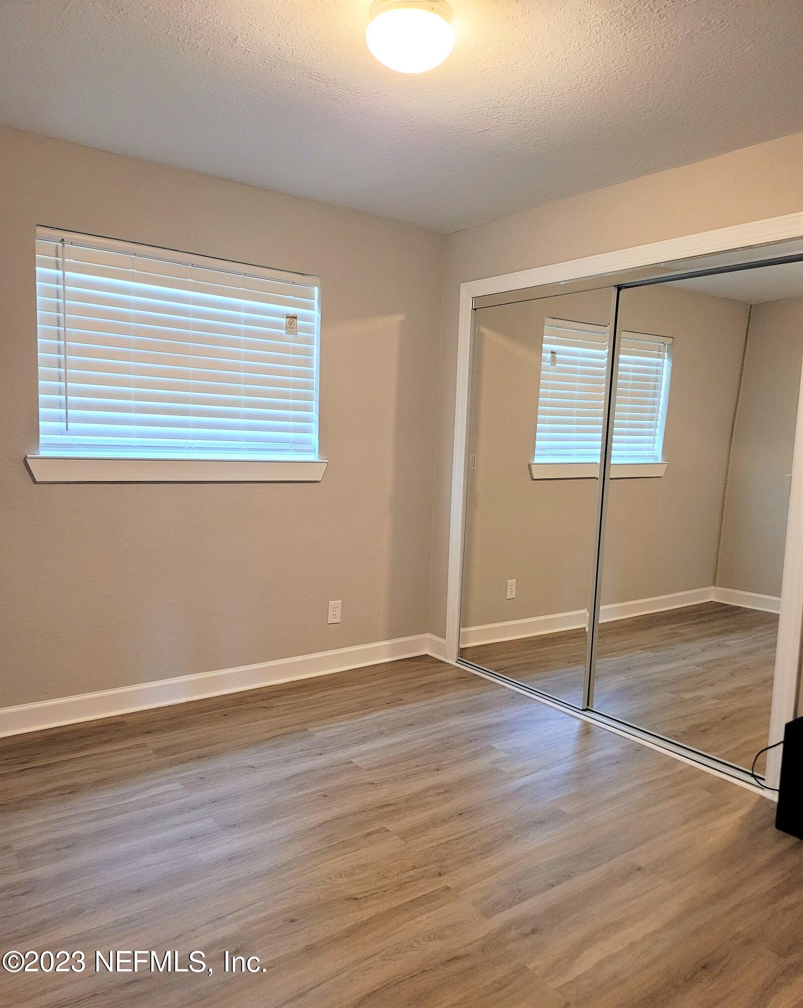 2627 Adele Road Jacksonville, FL 32216 - Photo 15 of 27 a view of an empty room with wooden floor and a window