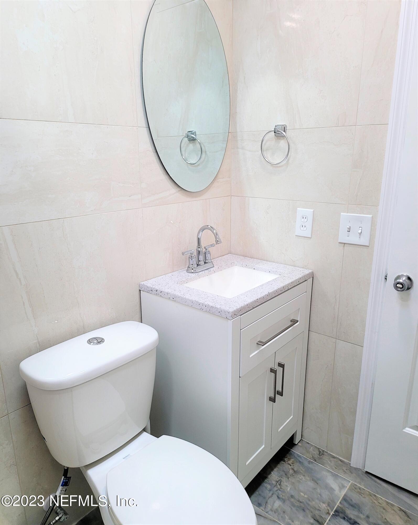 2627 Adele Road Jacksonville, FL 32216 - Photo 18 of 27 a bathroom with a toilet sink and mirror