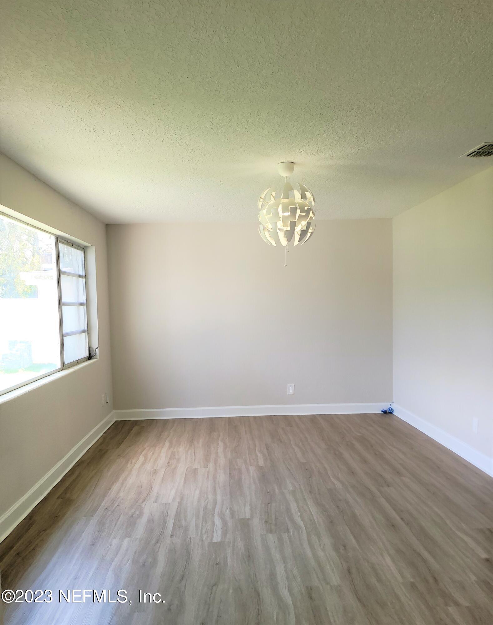 2627 Adele Road Jacksonville, FL 32216 - Photo 6 of 27 wooden floor in an empty room with a window