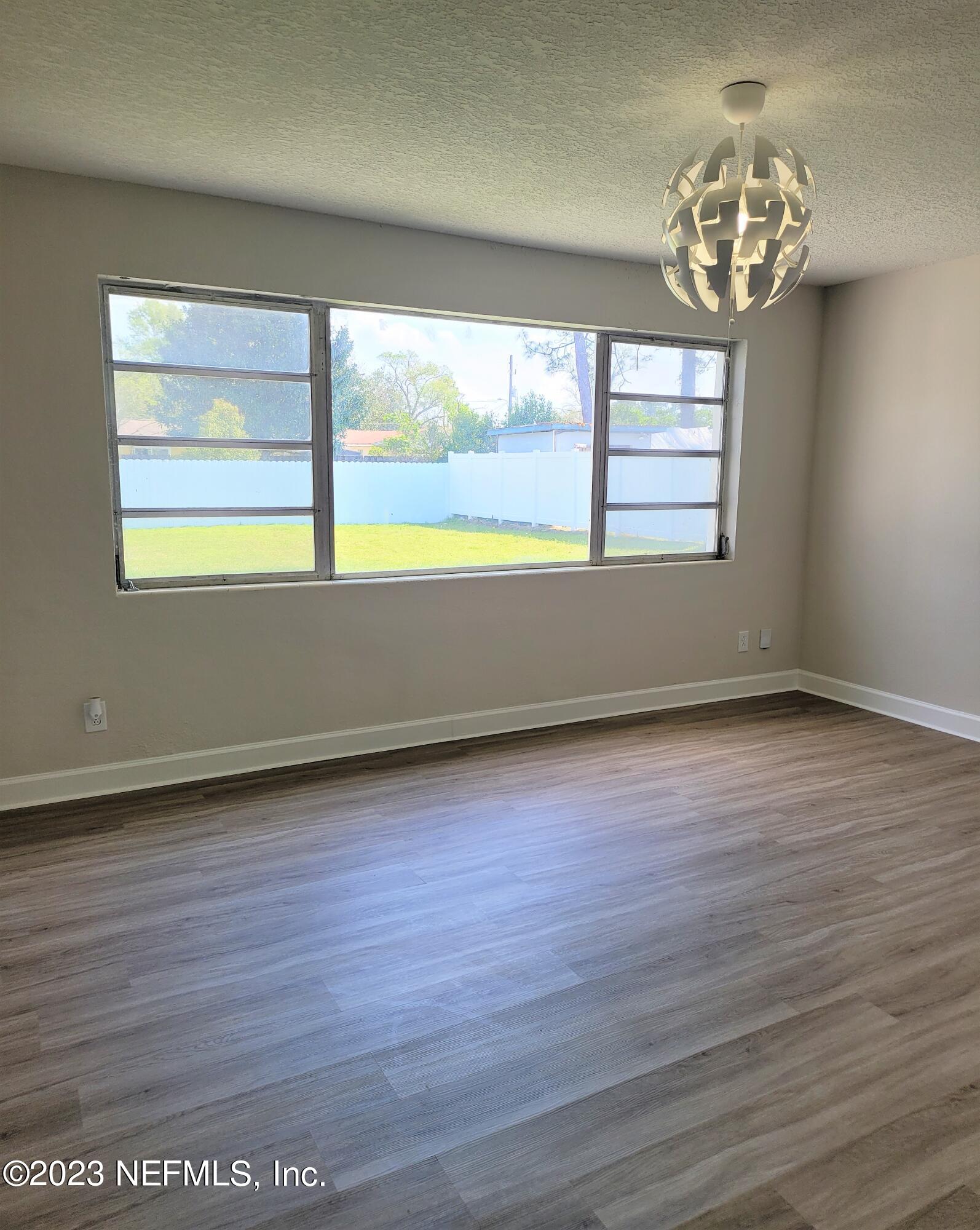 2627 Adele Road Jacksonville, FL 32216 - Photo 7 of 27 an empty room with wooden floor and windows