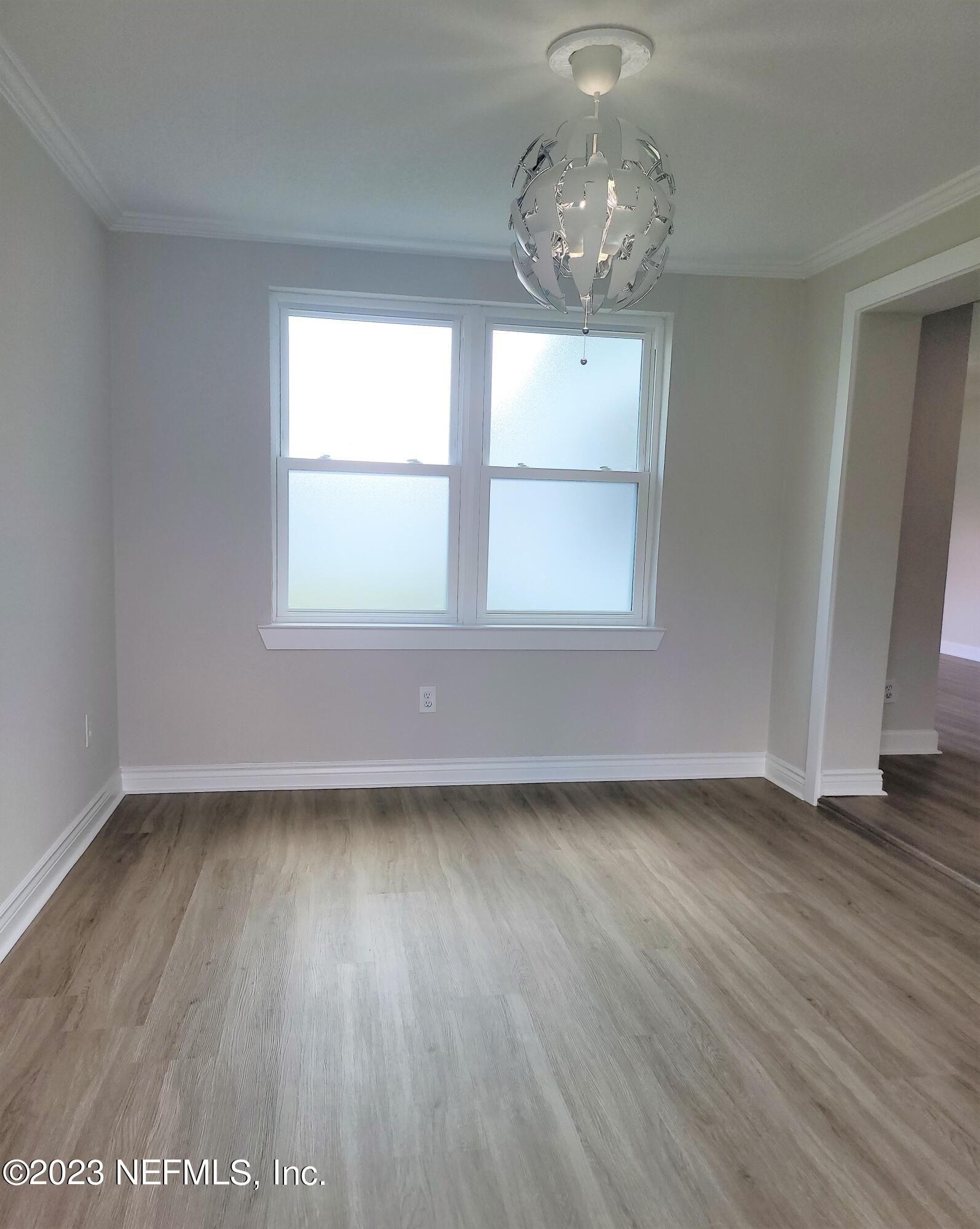 2627 Adele Road Jacksonville, FL 32216 - Photo 8 of 27 an empty room with wooden floor and windows