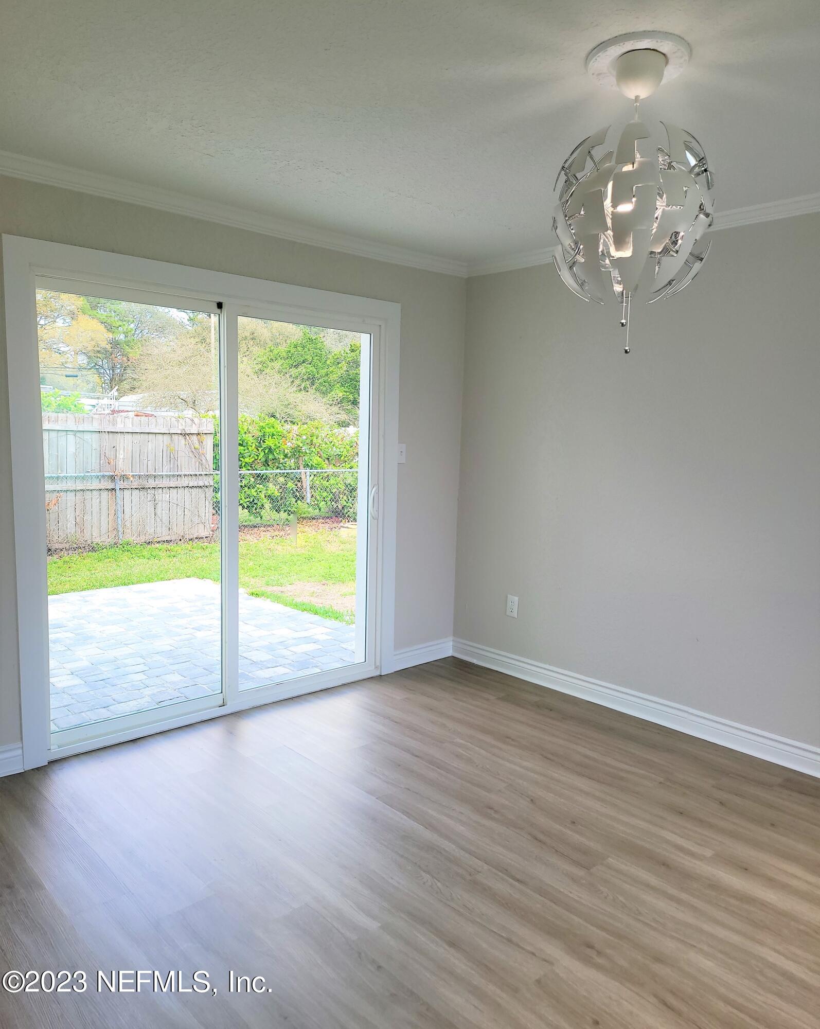 2627 Adele Road Jacksonville, FL 32216 - Photo 9 of 27 an empty room with wooden floor and windows