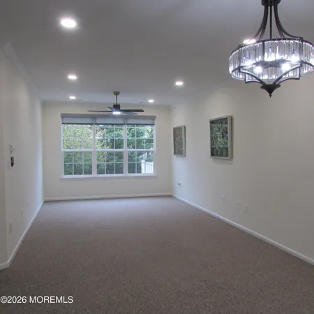 en empty room with windows and chandelier