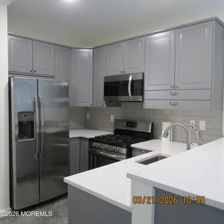 a kitchen with stainless steel appliances a refrigerator a sink a stove a microwave and cabinets