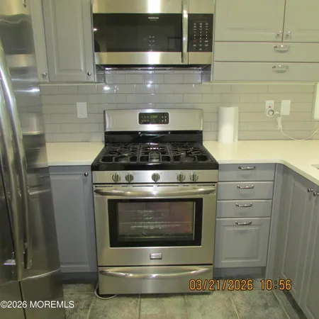 a stove top oven sitting inside of a kitchen