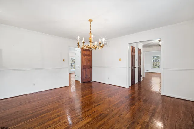 a view of a room with wooden floor and chandelier