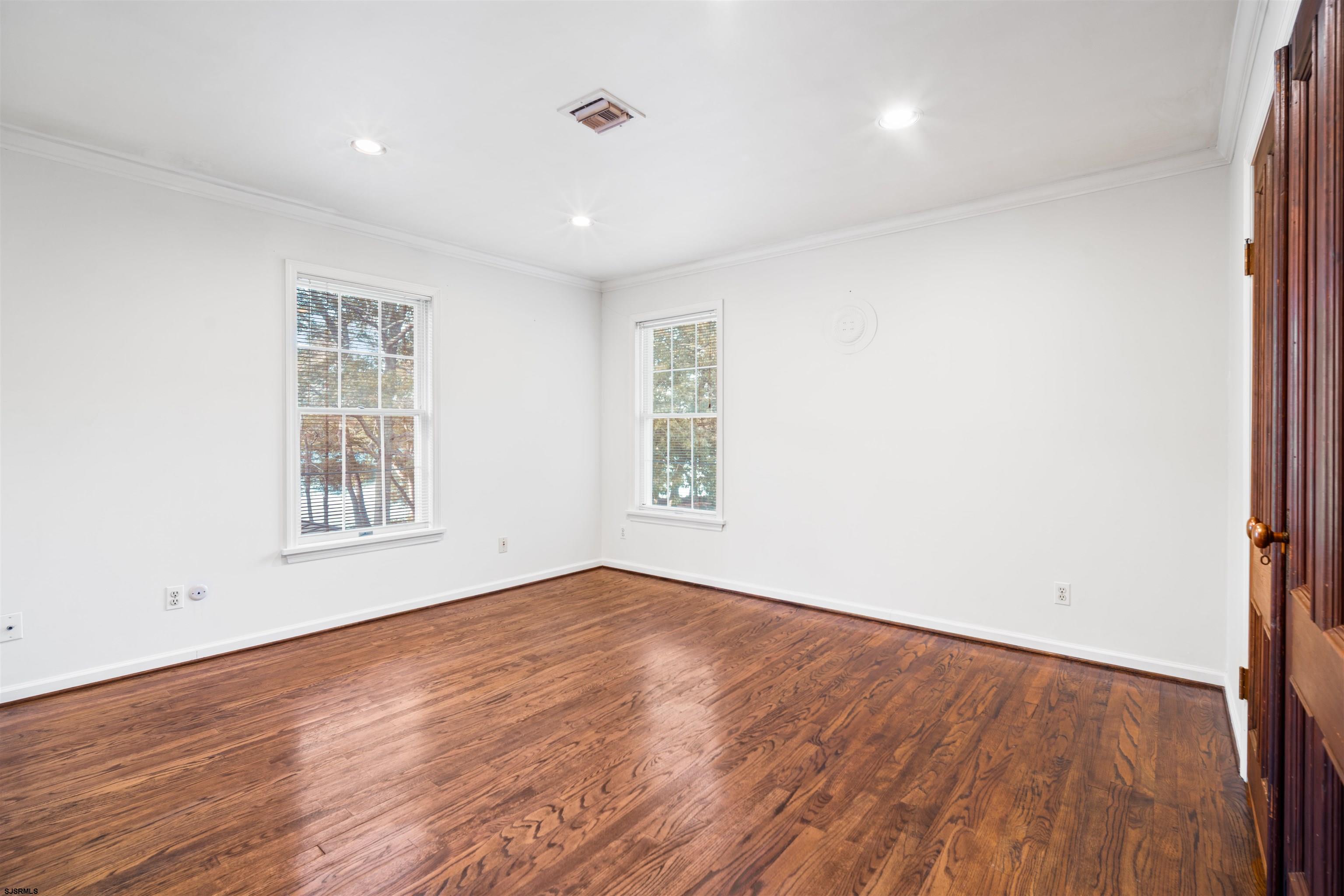 216 Riverside Drive Port Republic, NJ 08241 - Photo 21 of 47 an empty room with wooden floor and windows