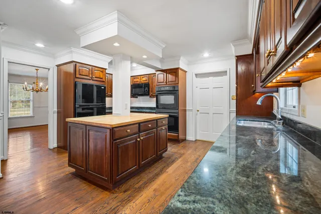 a kitchen with stainless steel appliances granite countertop a stove a sink and a refrigerator
