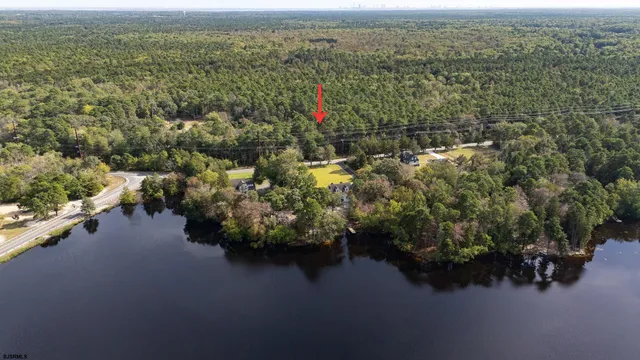 a view of a lake with a yard and fountain in the back