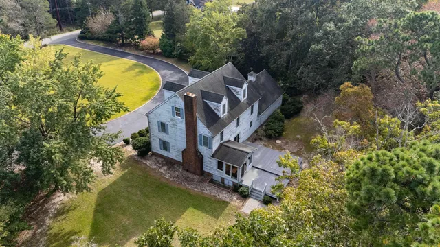 an aerial view of a house with a yard and lake view