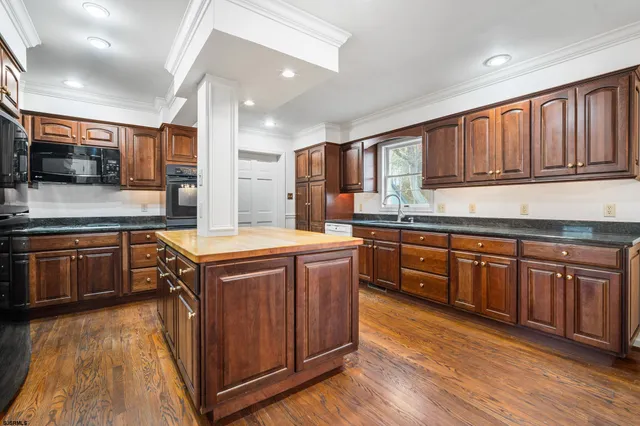 a kitchen with stainless steel appliances granite countertop wooden cabinets sink and stove