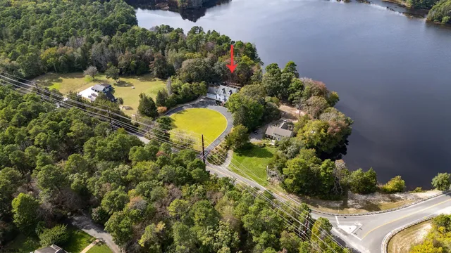 an aerial view of residential house with outdoor space and trees all around