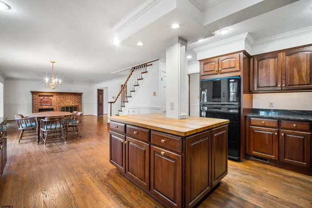 a kitchen with stainless steel appliances granite countertop a stove and a wooden floors
