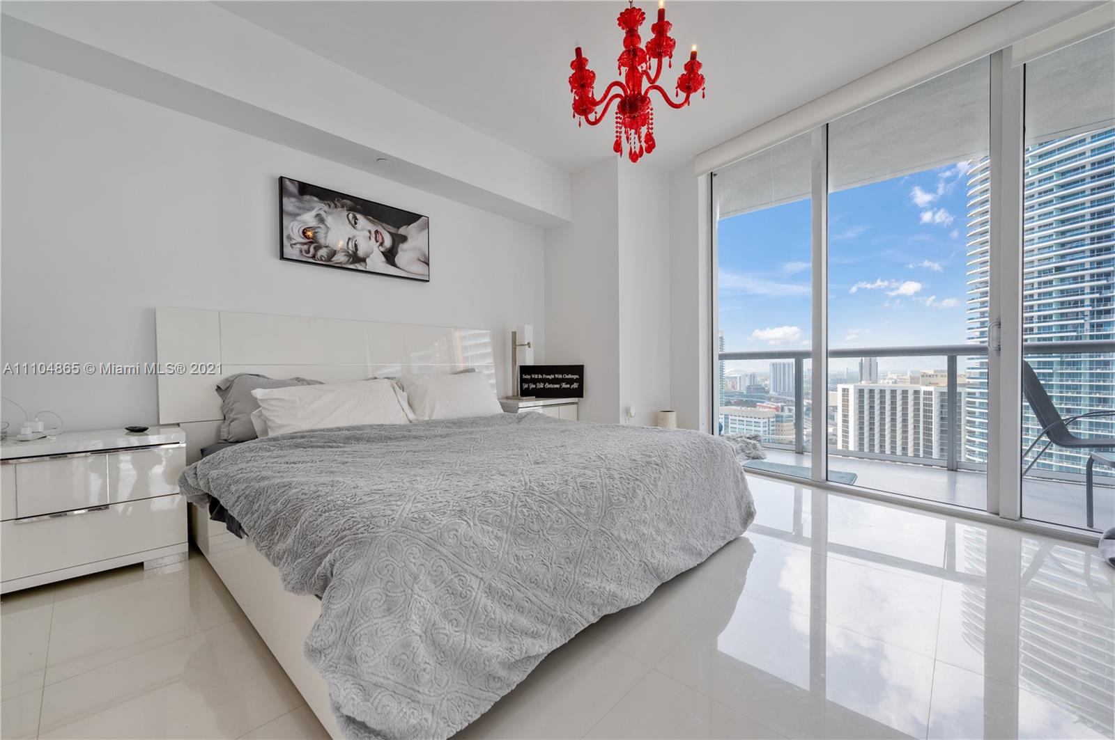 465 Brickell Avenue, Unit 2702 Miami, FL 33131 - Photo 17 of 37 a bedroom with a bed and a chandelier