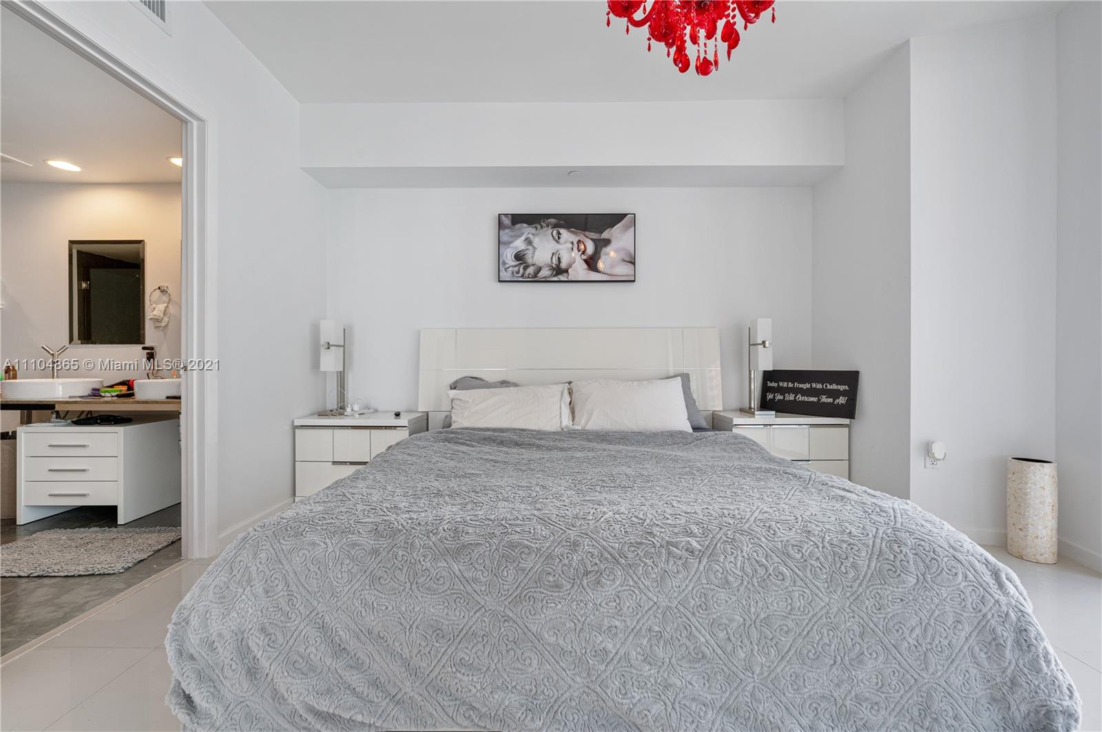 465 Brickell Avenue, Unit 2702 Miami, FL 33131 - Photo 19 of 37 a bedroom with a bed and a chandelier