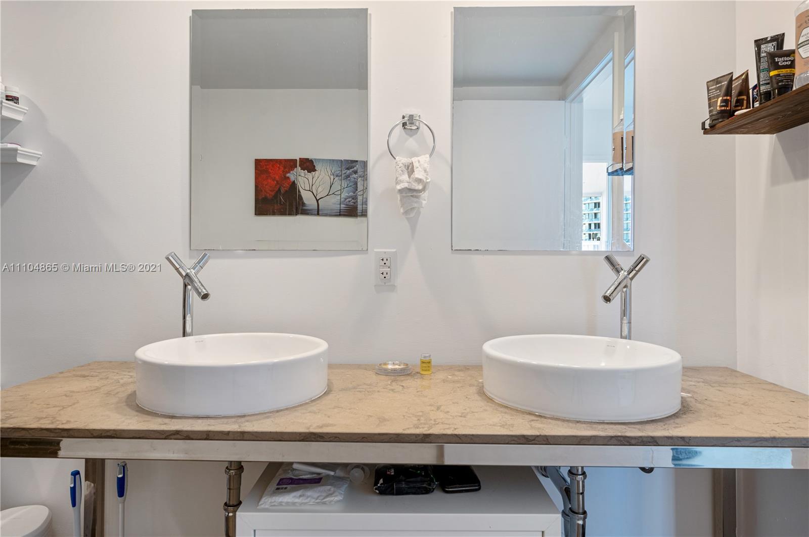 465 Brickell Avenue, Unit 2702 Miami, FL 33131 - Photo 22 of 37 a bathroom with a sink and a mirror