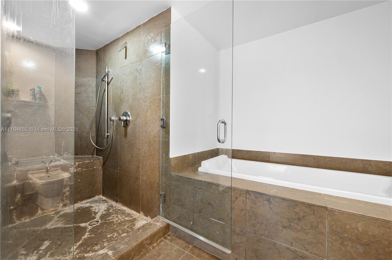 465 Brickell Avenue, Unit 2702 Miami, FL 33131 - Photo 23 of 37 a bathroom with a bathtub and a shower