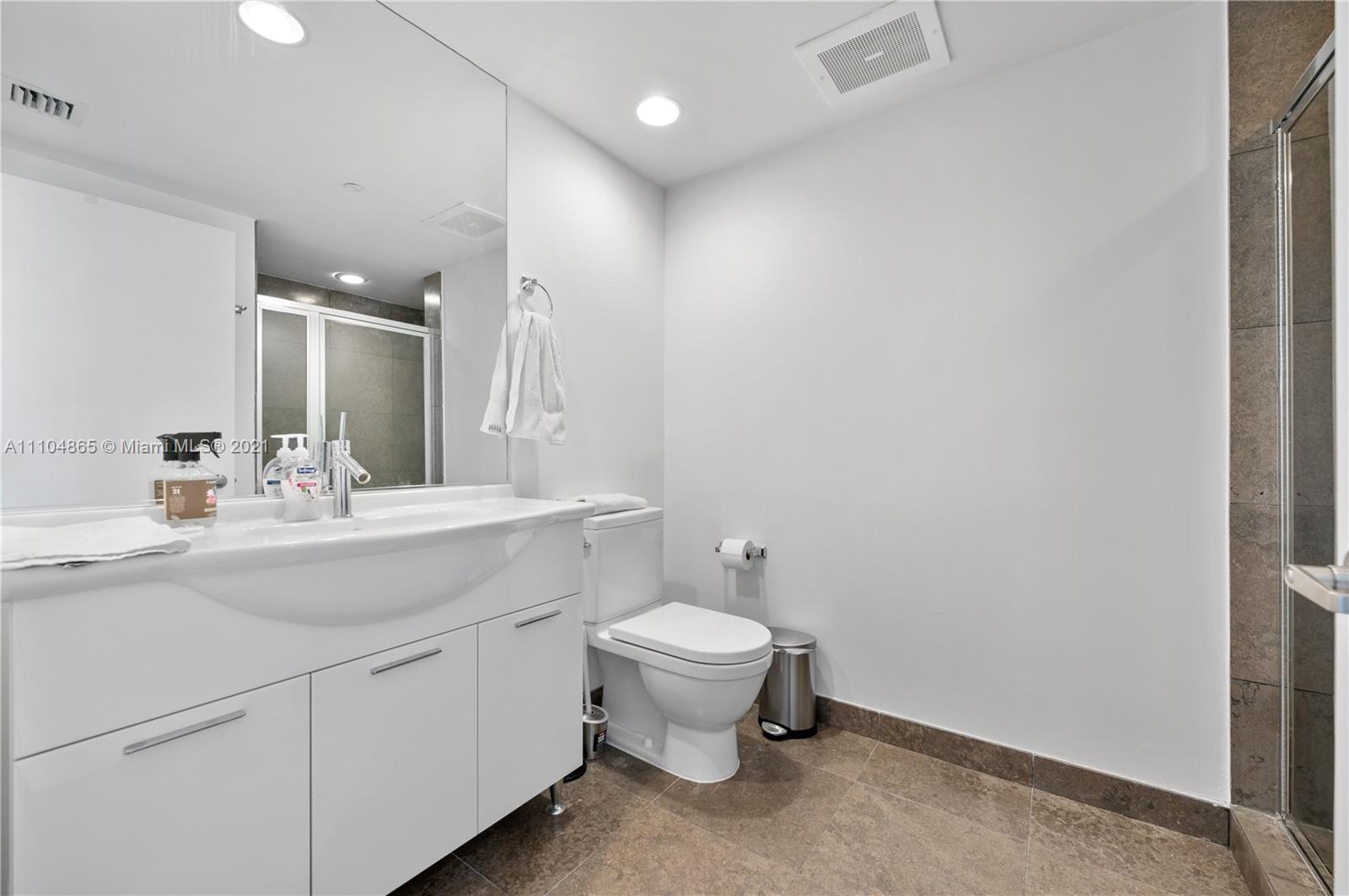 465 Brickell Avenue, Unit 2702 Miami, FL 33131 - Photo 30 of 37 a bathroom with a toilet sink and mirror
