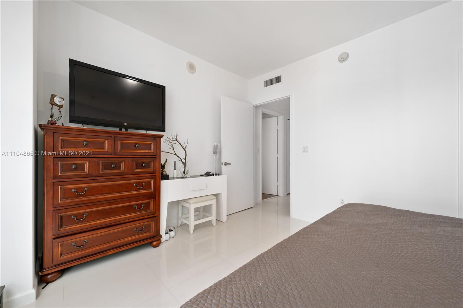 465 Brickell Avenue, Unit 2702 Miami, FL 33131 - Photo 31 of 37 a room with furniture and flat screen tv