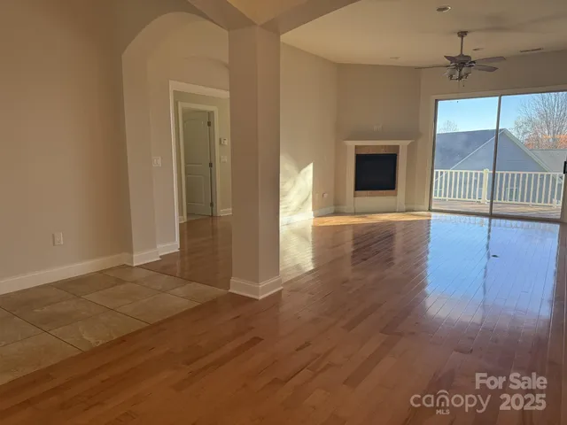 a view of an empty room with glass door and wooden floor
