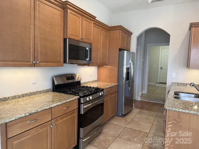 a kitchen with granite countertop a stove and a refrigerator