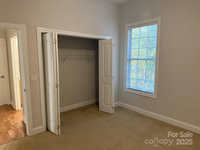 an empty room with windows and closet
