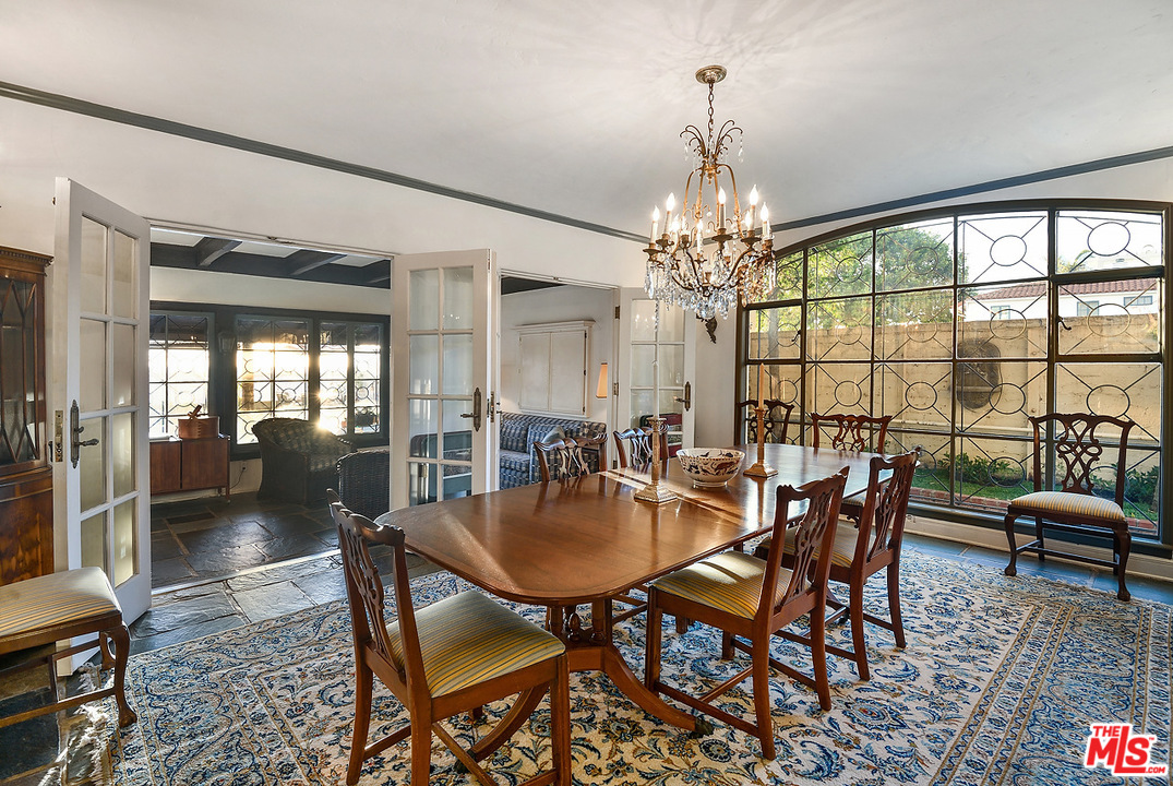 1038 Palisades Beach Road Santa Monica, CA 90403 - Photo 7 of 18 a dining room with furniture a chandelier and wooden floor
