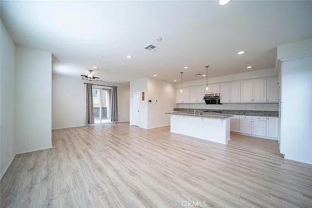 a view of kitchen with granite countertop cabinets and refrigerator