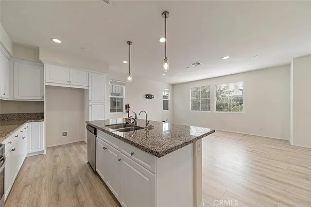 a kitchen with sink cabinets and wooden floor