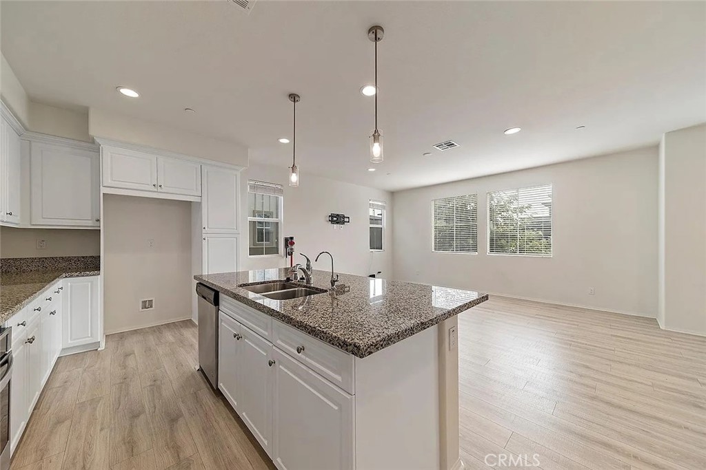 7364 Solstice Place Rancho Cucamonga, CA 91739 - Photo 7 of 19 a kitchen with sink cabinets and wooden floor