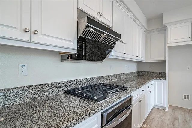 a kitchen with white cabinets and appliances